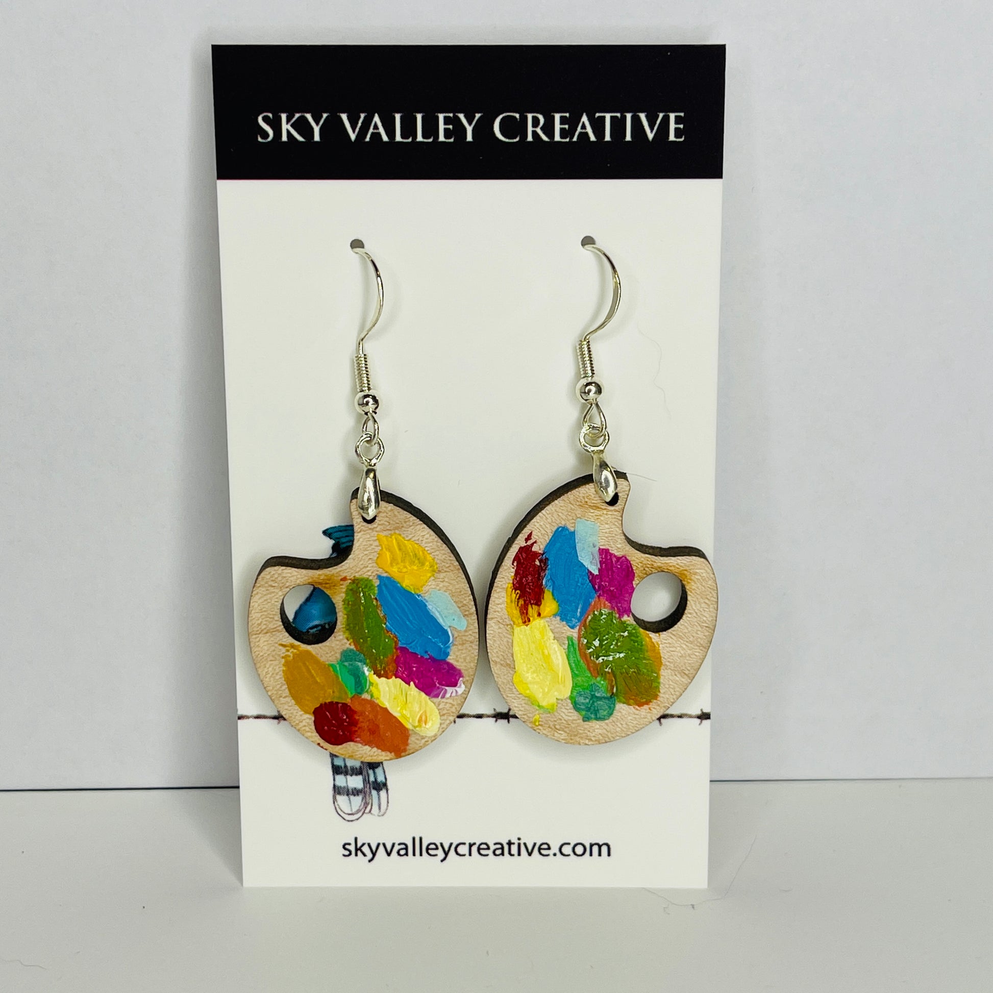 Solid maple earrings in summer colors. Front view on card.