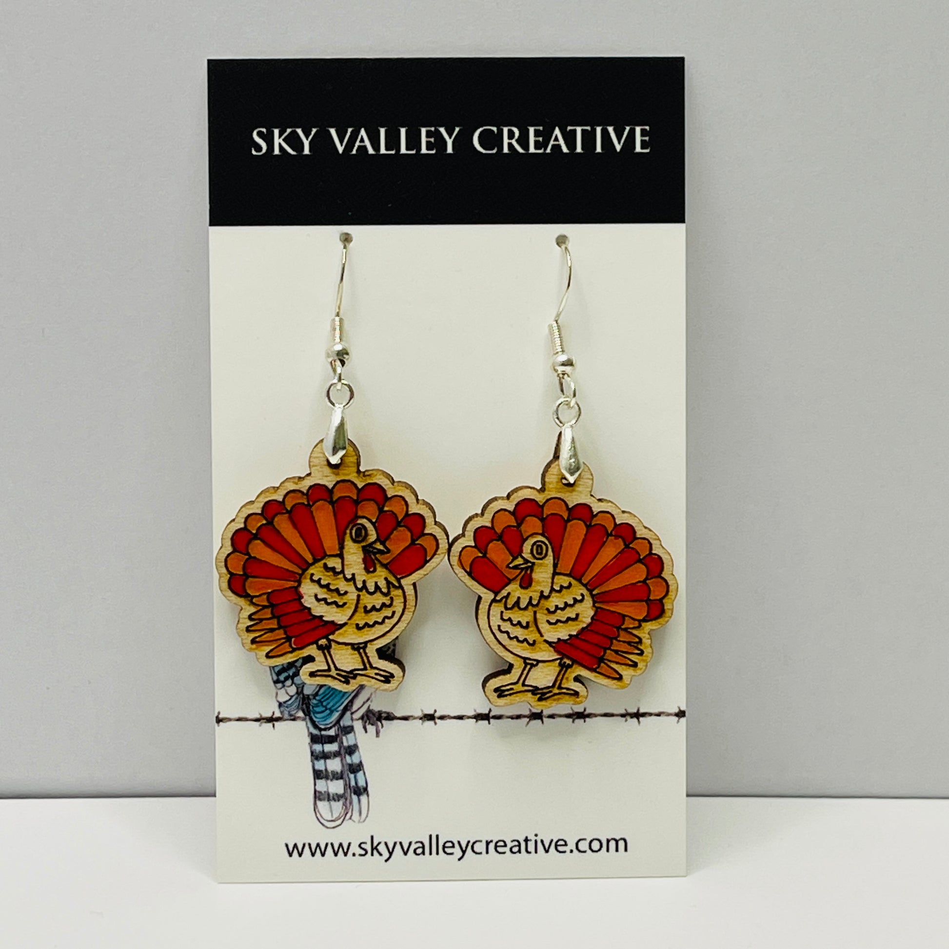Turkey-shaped laser-cut and hand-painted earrings on a 'Sky Valley Creative' branded card.