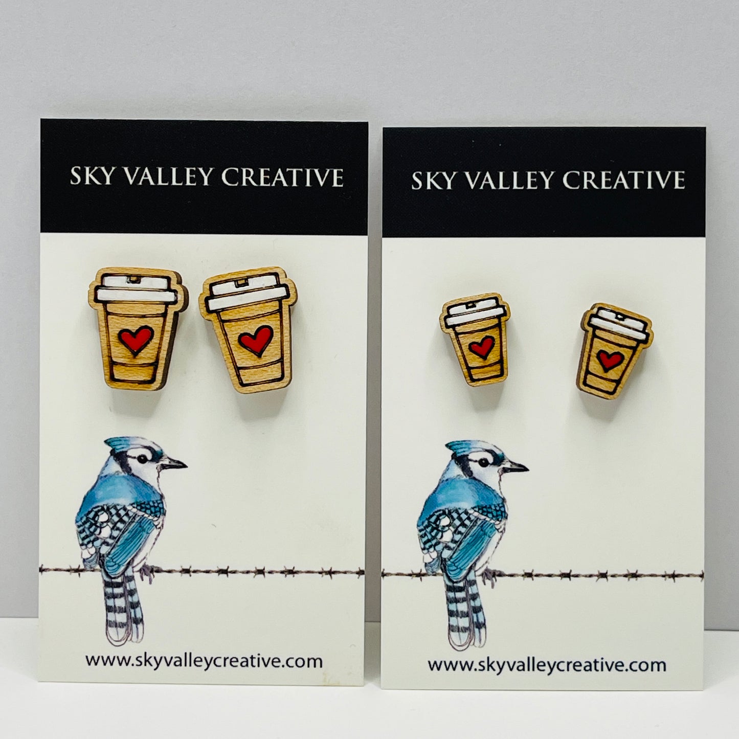 Two pairs of coffee cup post earrings with hearts on display cards with 'Sky Valley Creative' branding. Regular and small sizes shown.