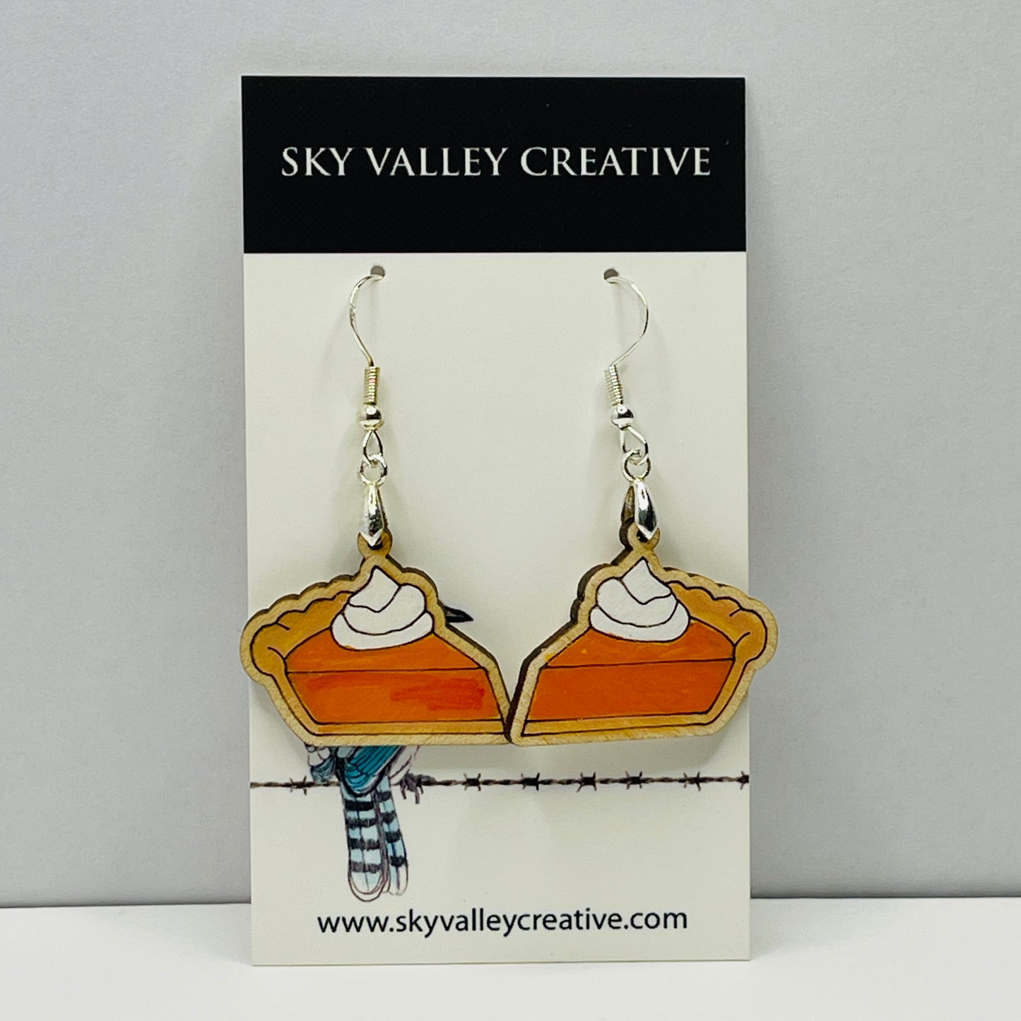 Lser Cut and hand-painted maple pumpkin pie earrings on a 'Sky Valley Creative' branded card.